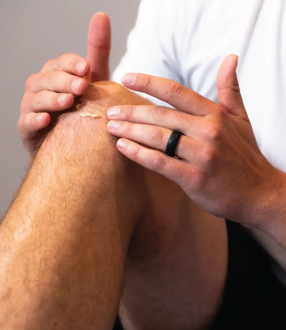 Man applying SomaDerm + AWE to Knee
